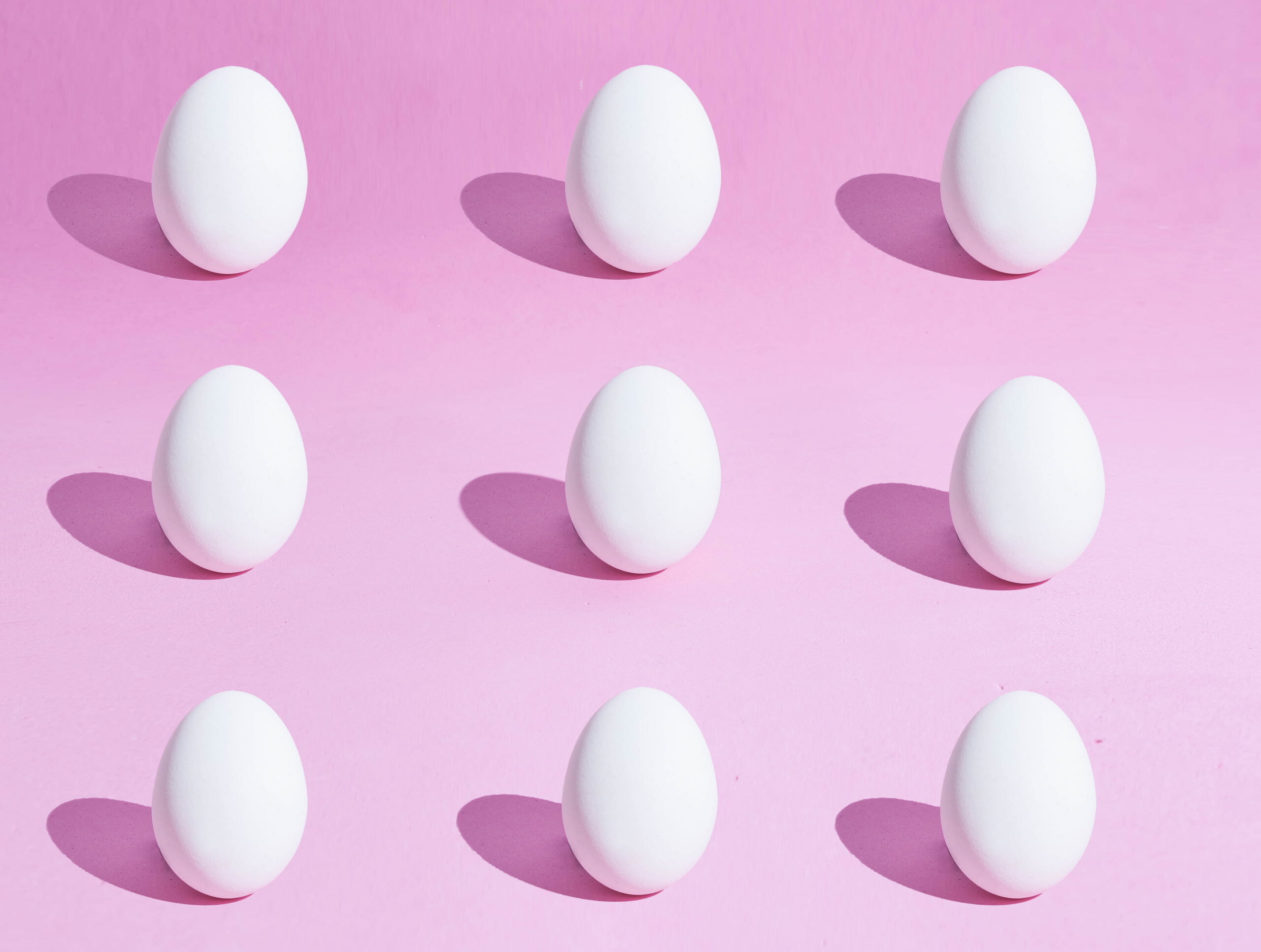 llustratie van meerdere eieren tegen een roze achtergrond, ter illustratie van het eicelaantal en het aantal beschikbare eicellen in de eierstokken.